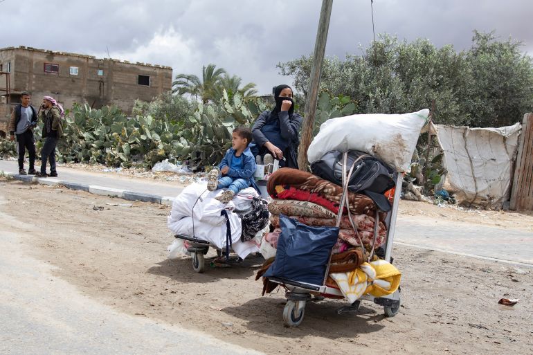 epa11321291 An Internally displaced Palestinian woman and child with their belongings at a street after an evacuation order issued by the Israeli army, in Rafah, southern Gaza Strip, 06 May 2024. The Israeli military stated on 06 May that the IDF has called on the residents of eastern Rafah to 'temporarily' evacuate to an expanded humanitarian area. The statement came ahead of an expected Israeli offensive on the city. More than 34,600 Palestinians and over 1,455 Israelis have been killed, according to the Palestinian Health Ministry and the Israel Defense Forces (IDF), since Hamas militants launched an attack against Israel from the Gaza Strip on 07 October 2023, and the Israeli operations in Gaza and the West Bank which followed it. EPA-EFE/HAITHAM IMAD