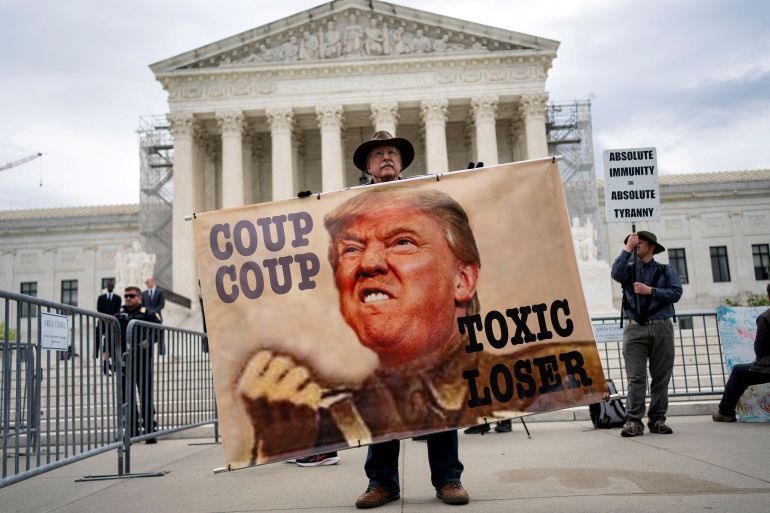 A demonstrator holds a sign outside the U.S. Supreme Court as the justices hear arguments on former President Trump’s claim of presidential immunity over criminal charges over his efforts to overturn the 2020 presidential election results in Washington, U.S., April 25, 2024. REUTERS/Bonnie Cash TPX IMAGES OF THE DAY