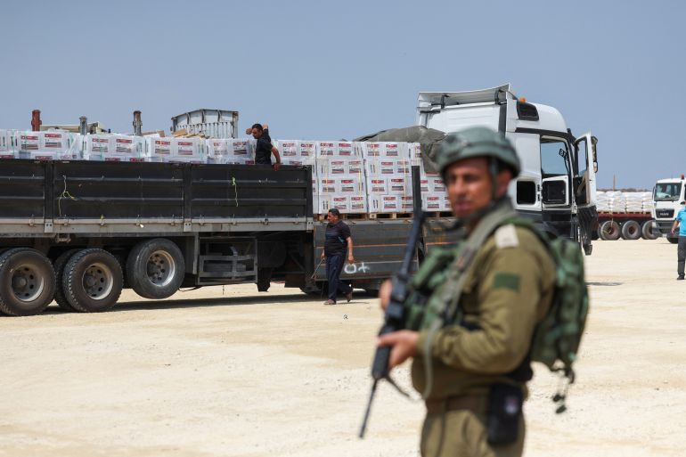 An Israeli soldier stands guard near humanitarian aid near the Beit Hanoon crossing point in northern Gaza, May 1, 2024. [Ronen Zvulun/Reuters]
