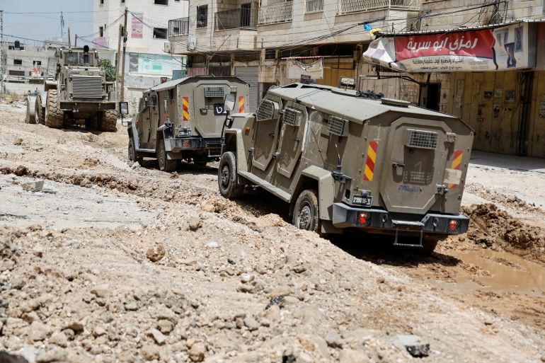 Israeli military vehicles are seen in Jenin, in the Israeli-occupied West Bank, May 21, 2024. REUTERS/Raneen Sawafta