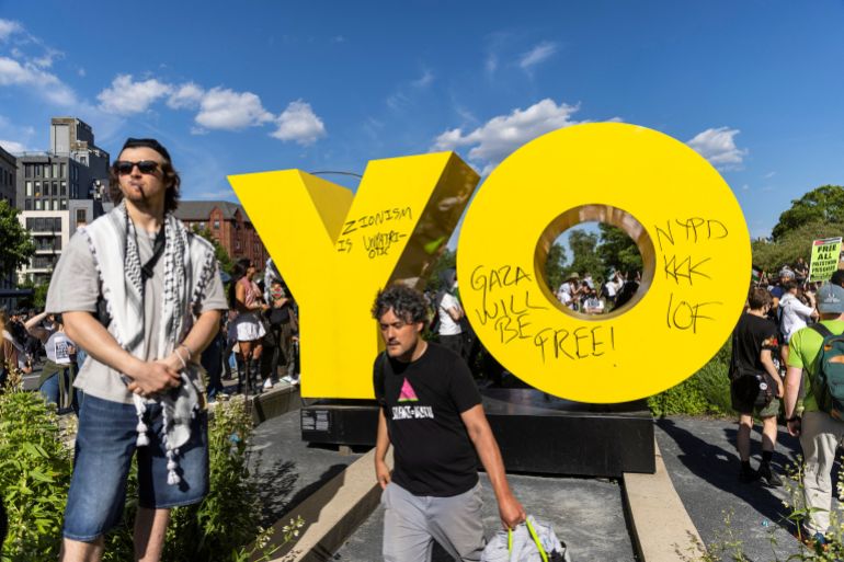 Pro-Palestinian protestors stand next to The Brooklyn Museum's 'OY/YO' sculpture after it was graffitied during a protest, amid the ongoing conflict between Israel and the Palestinian Islamist group Hamas in Gaza, in the Brooklyn borough of New York City, U.S., May 31, 2024. REUTERS/Eduardo Munoz