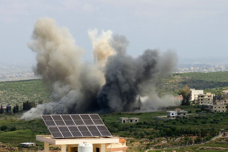an explosion is seen near solar panels on a green hill