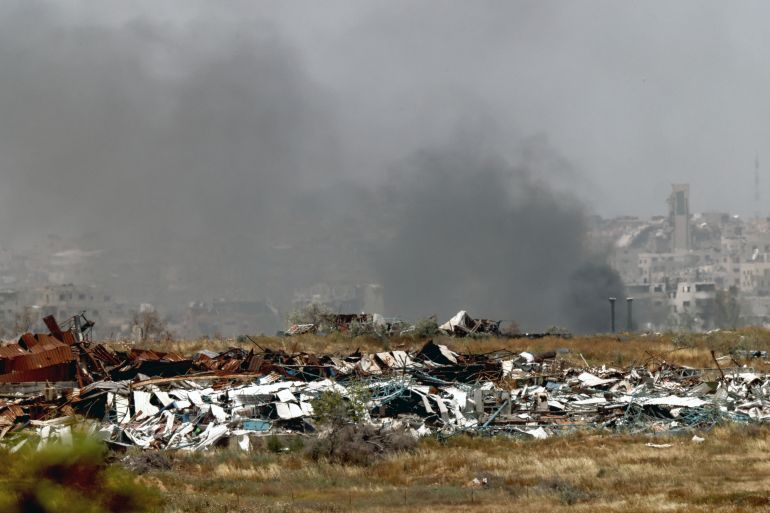 smoke rises from destroyed buildings