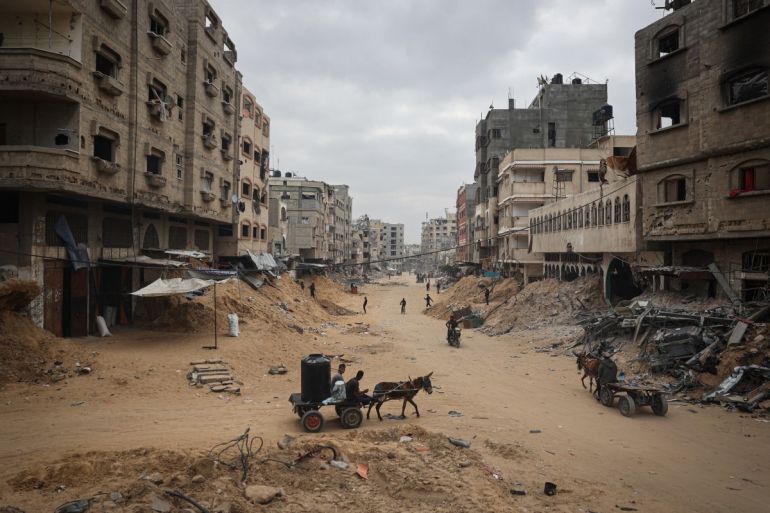 Palestinians walk between damaged buildings in Khan Yunis in the southern Gaza Strip on May 2, 2024, amid the ongoing conflict between Israel and the Hamas movement. (Photo by AFP)