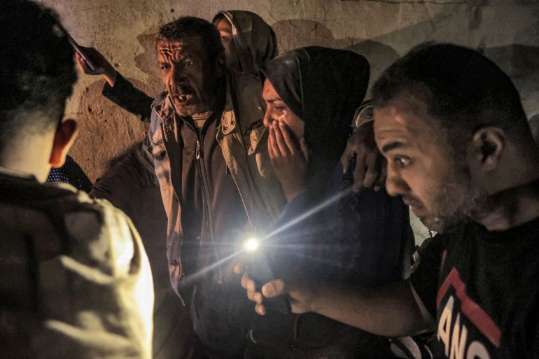 Palestinian family members react as they gather around a wounded relative (not pictured) as civil defence teams help rescue victims from the destroyed al-Qadri family home which was struck by Israeli bombardment in Rafah in the southern Gaza Strip late on May 7, 2024 amid the ongoing conflict between Israel and the militant group Hamas. (Photo by AFP)
